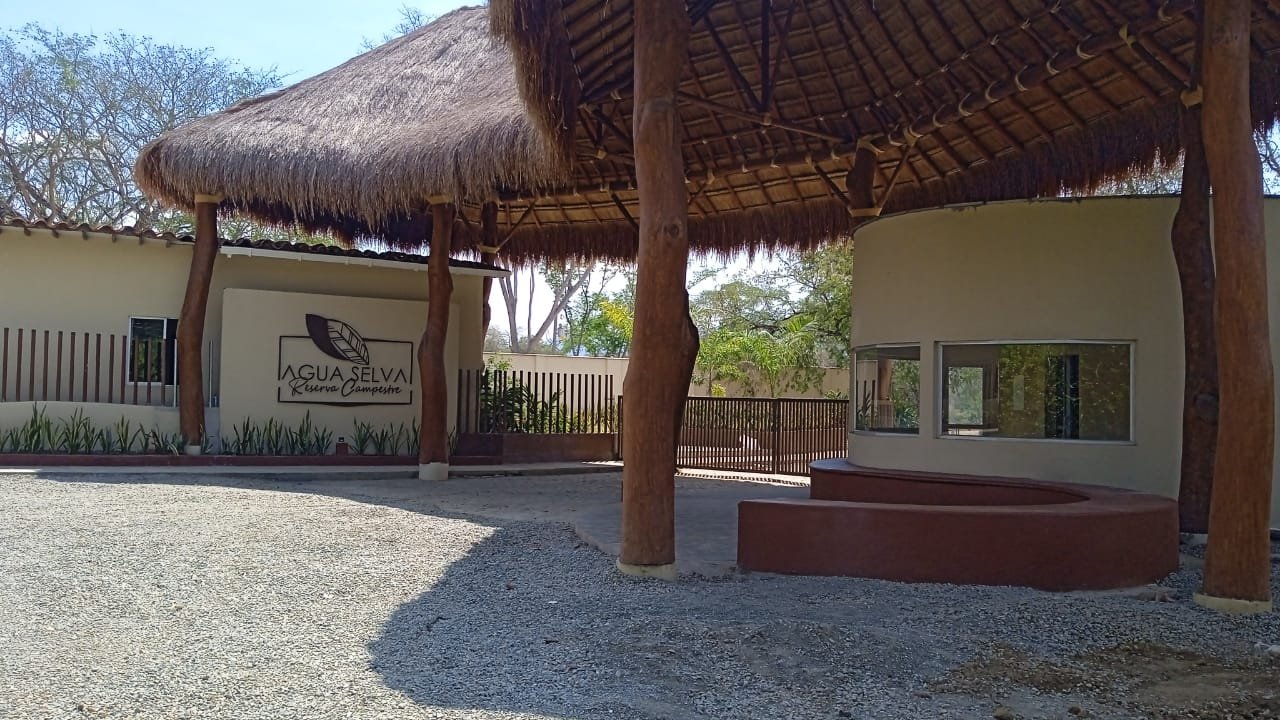 Zona de portería de Agua Selva con el quiosco de acceso y el muro del logo